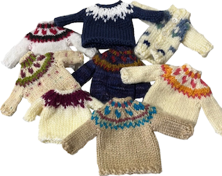 display of eight mini sweaters of various styles, including five Little Lopapeysa sweaters in various colors (white, blue, tan)